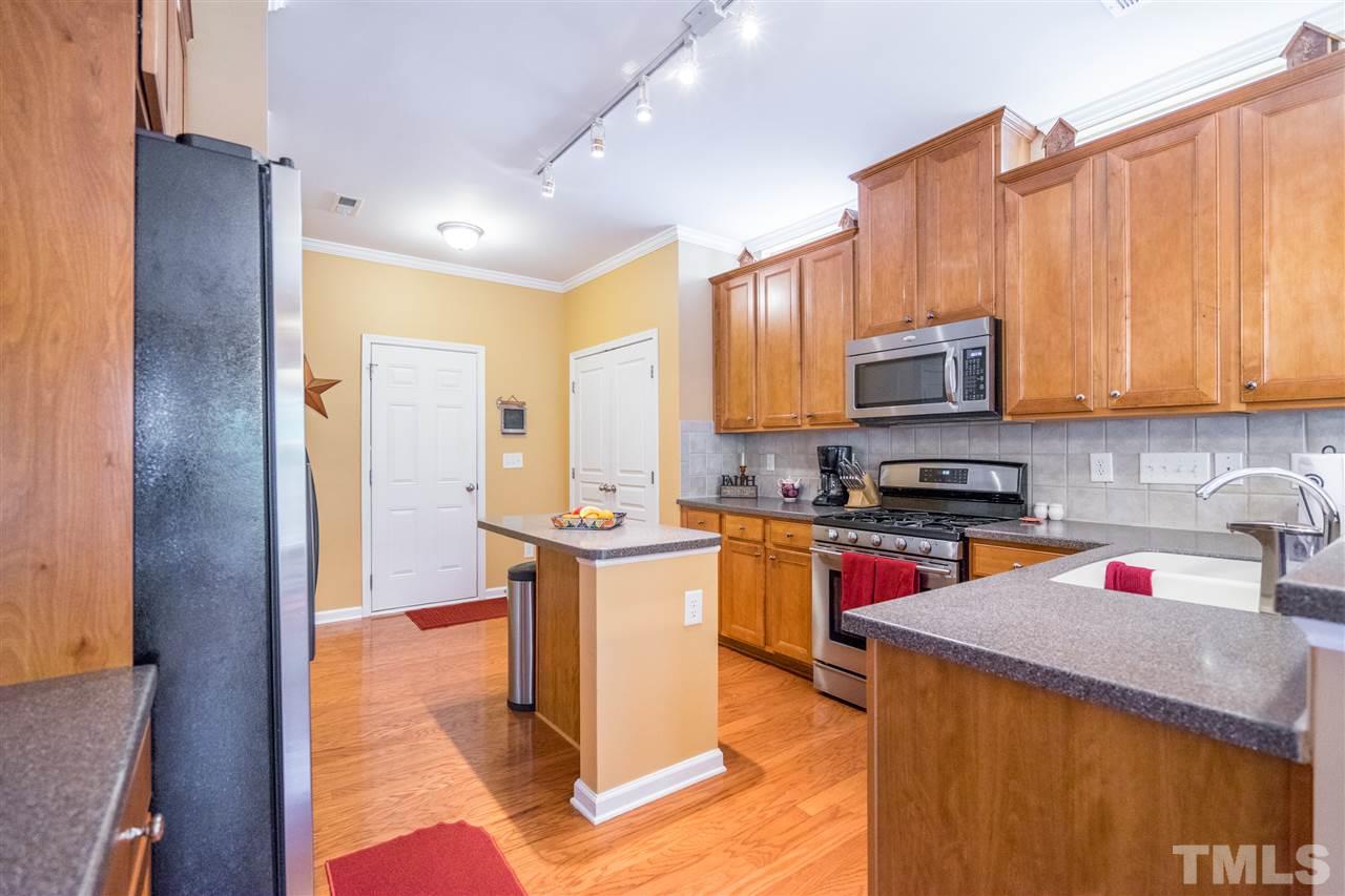 3307 Ranbir Drive Durham, NC 27713 - Photo 11 of 25 a kitchen with kitchen island granite countertop a sink appliances and cabinets