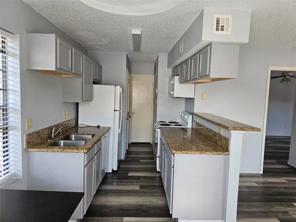 a kitchen with granite countertop a sink and a stove