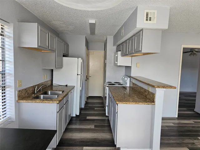 a kitchen with granite countertop a sink and a stove