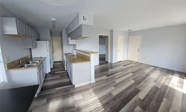 a kitchen with a sink a refrigerator a stove and white cabinets