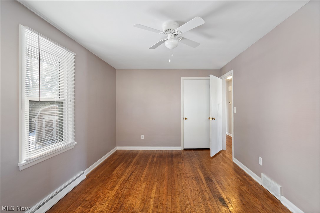 136 South Metzger Avenue Rittman, OH 44270 - Photo 11 of 33 Unfurnished room with baseboard heating, dark wood finished floors, and ceiling fan