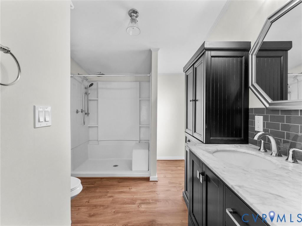 4772 Carsley Road Waverly, VA 23890 - Photo 16 of 38 Bathroom with a shower stall, vanity, light wood f