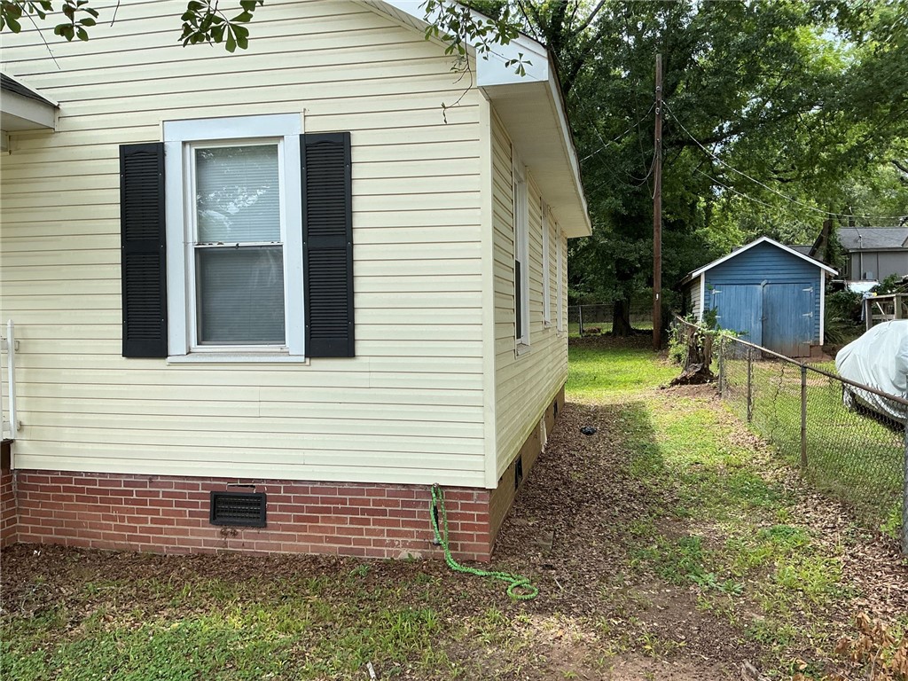 504 Caughlin Avenue Anderson, SC 29624 - Photo 14 of 15 A well-maintained side exterior boasts durable siding and a manicured lawn leading to a useful outbuilding.