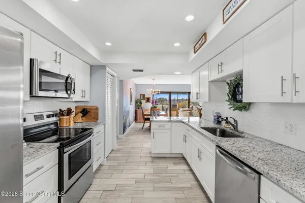 a kitchen with stainless steel appliances granite countertop a stove microwave and refrigerator