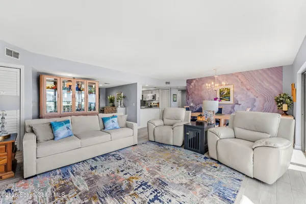 a living room with furniture and a floor to ceiling window