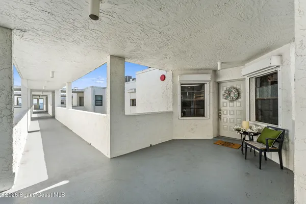 a view of a hallway with wooden floor and a living room