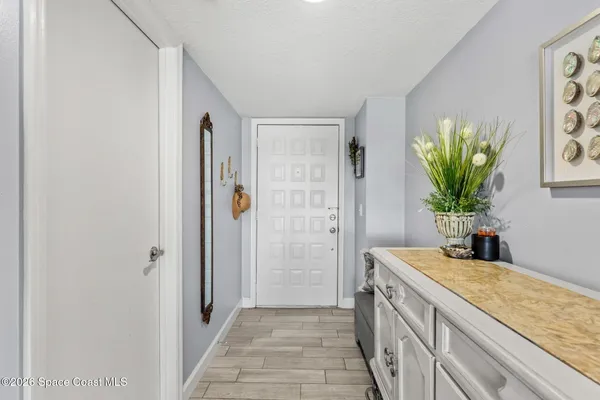 a view of a hallway with dining room and wooden floor