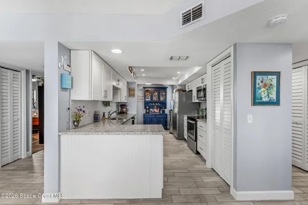 a large kitchen with stainless steel appliances granite countertop a sink and dishwasher a stove top oven with wooden floor