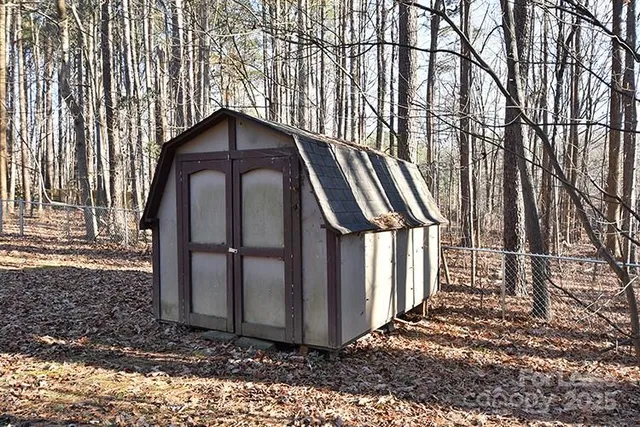 a view of a house with a yard and large trees