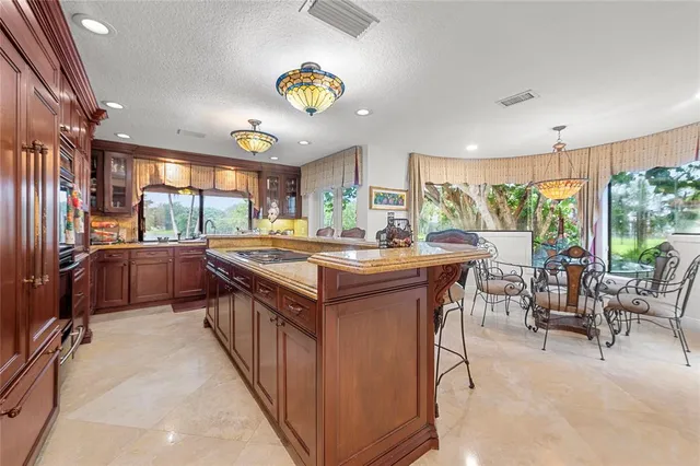 a kitchen with kitchen island a sink and a large window