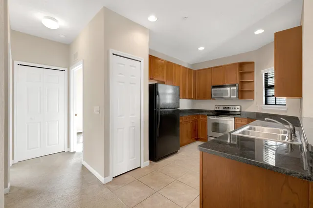 a kitchen with granite countertop a refrigerator and a sink