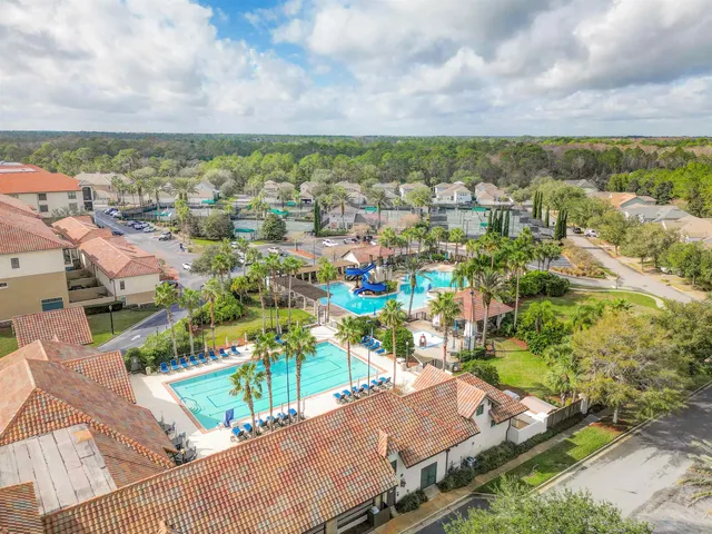 an aerial view of residential houses with outdoor space and trees
