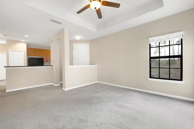 an empty room with windows and ceiling fan