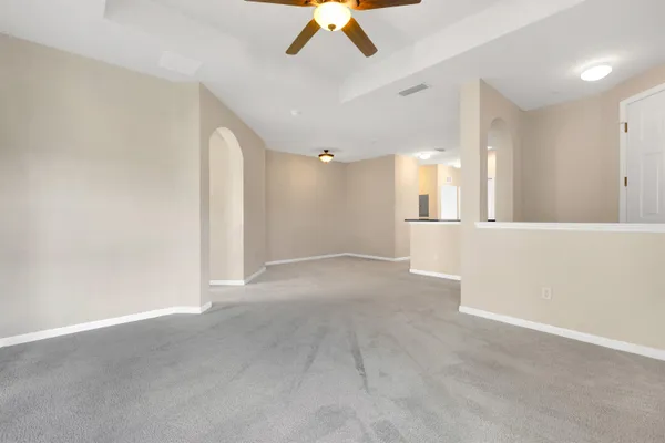 an empty room with a ceiling fan and window