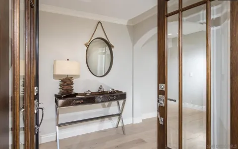 a living room with table mirror and a wooden floor