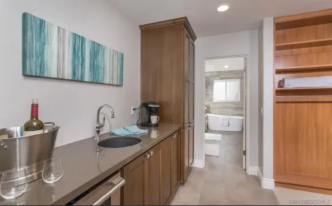 a en suite bathroom with a granite countertop sink and a mirror