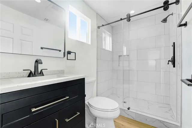 a bathroom with a sink a toilet and shower