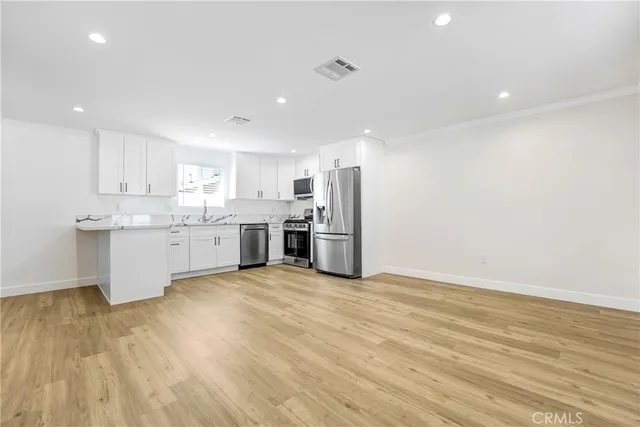 a large kitchen with stainless steel appliances granite countertop a stove a sink and a refrigerator