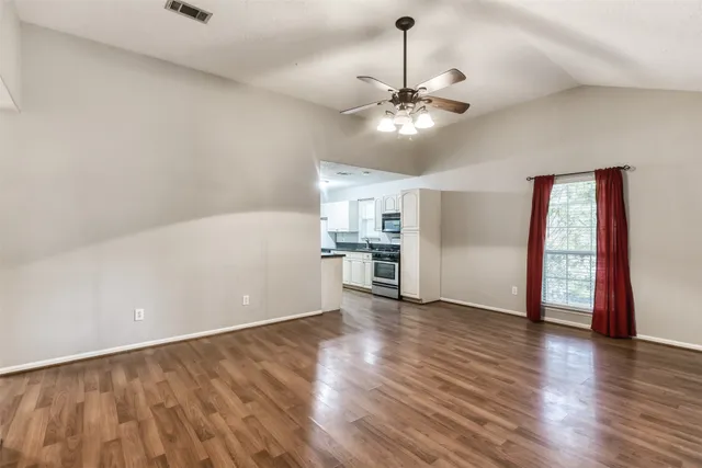 a view of empty room with wooden floor
