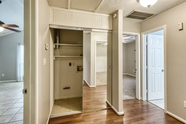 a view of a hallway with wooden floor and closet