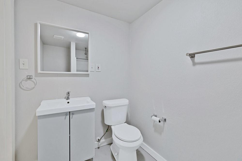 608 West Hickory Street, Unit B Denton, TX 76201 - Photo 9 of 19 a bathroom with a toilet sink and mirror