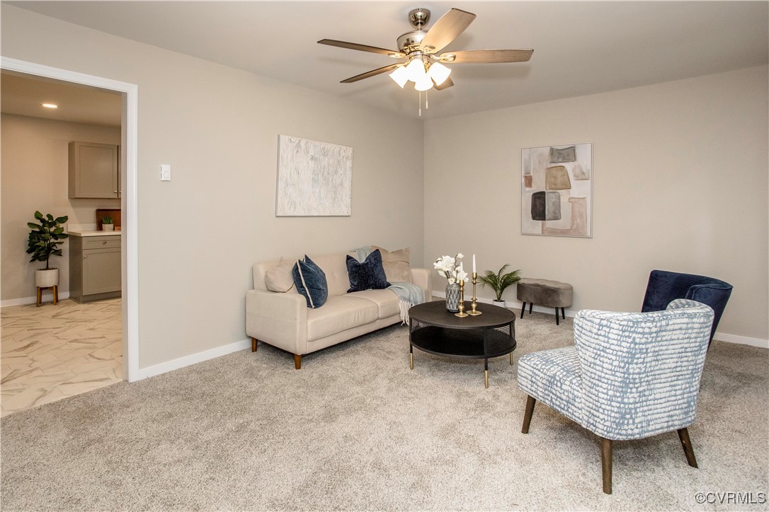 Living room featuring a ceiling fan, light marble