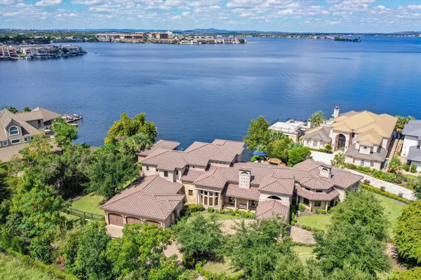 an aerial view of a house with a yard and lake view
