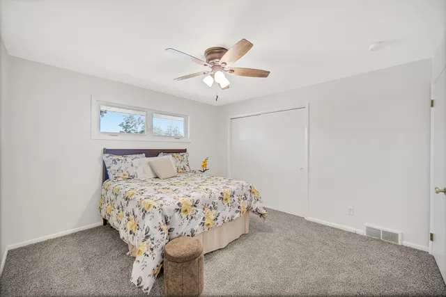 a bedroom with a bed and a ceiling fan