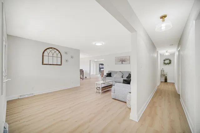 a view of a big room with wooden floor and windows