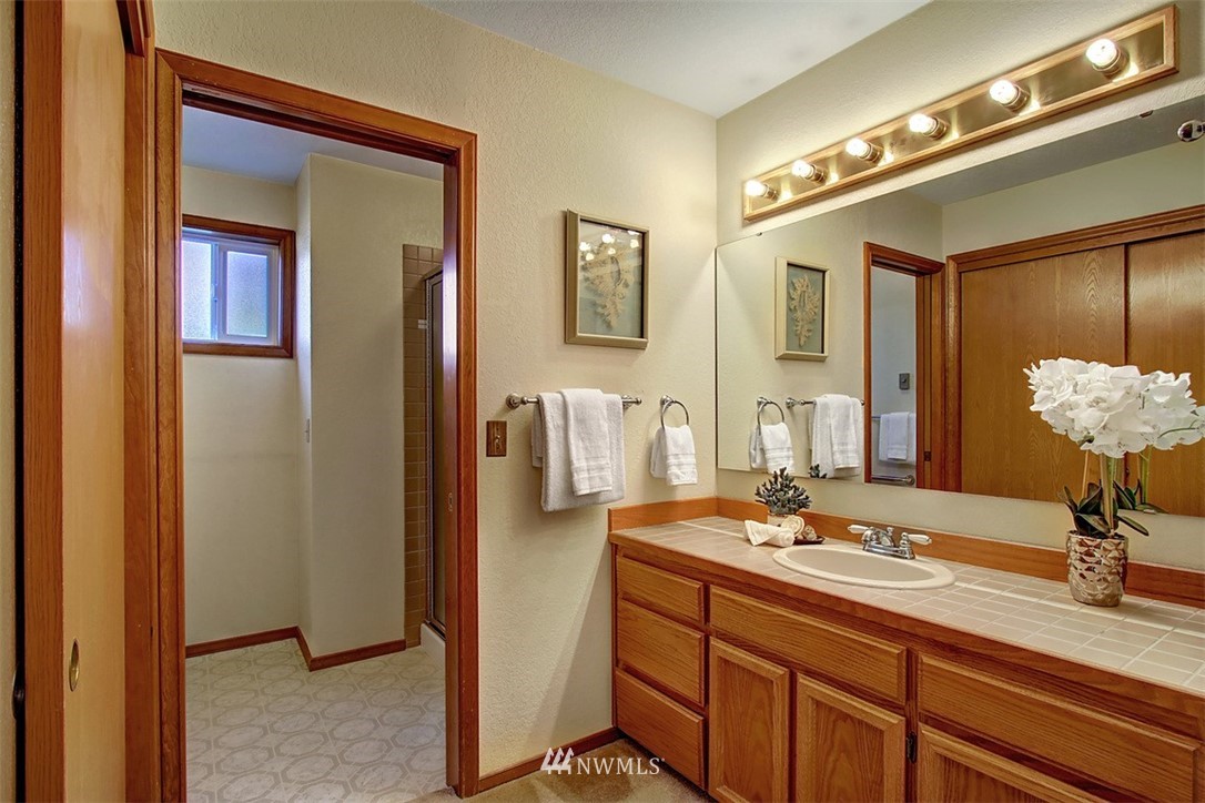 633 Main Street, Unit 103 Edmonds, WA 98020 - Photo 14 of 18 a bathroom with a double vanity sink and a mirror