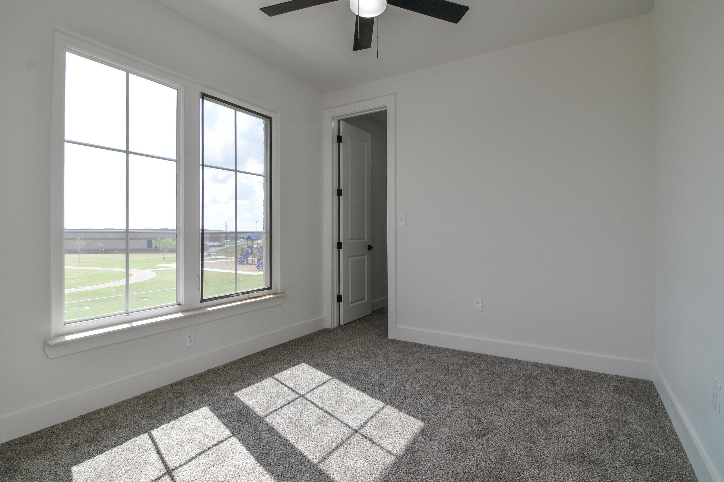 7801 56th Street Lubbock, TX 79407 - Photo 25 of 29 an empty room with chandelier fan and windows