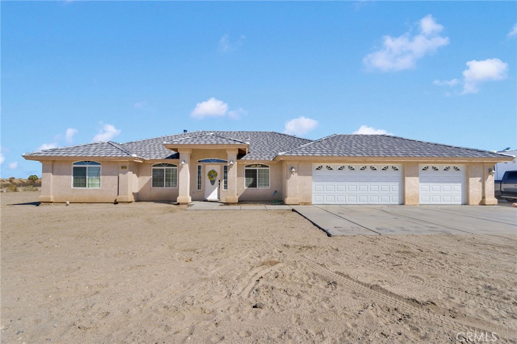 12871 Alta Vista Road Pinon Hills, CA 92372 - Photo 1 of 40 a front view of a house with a yard and garage