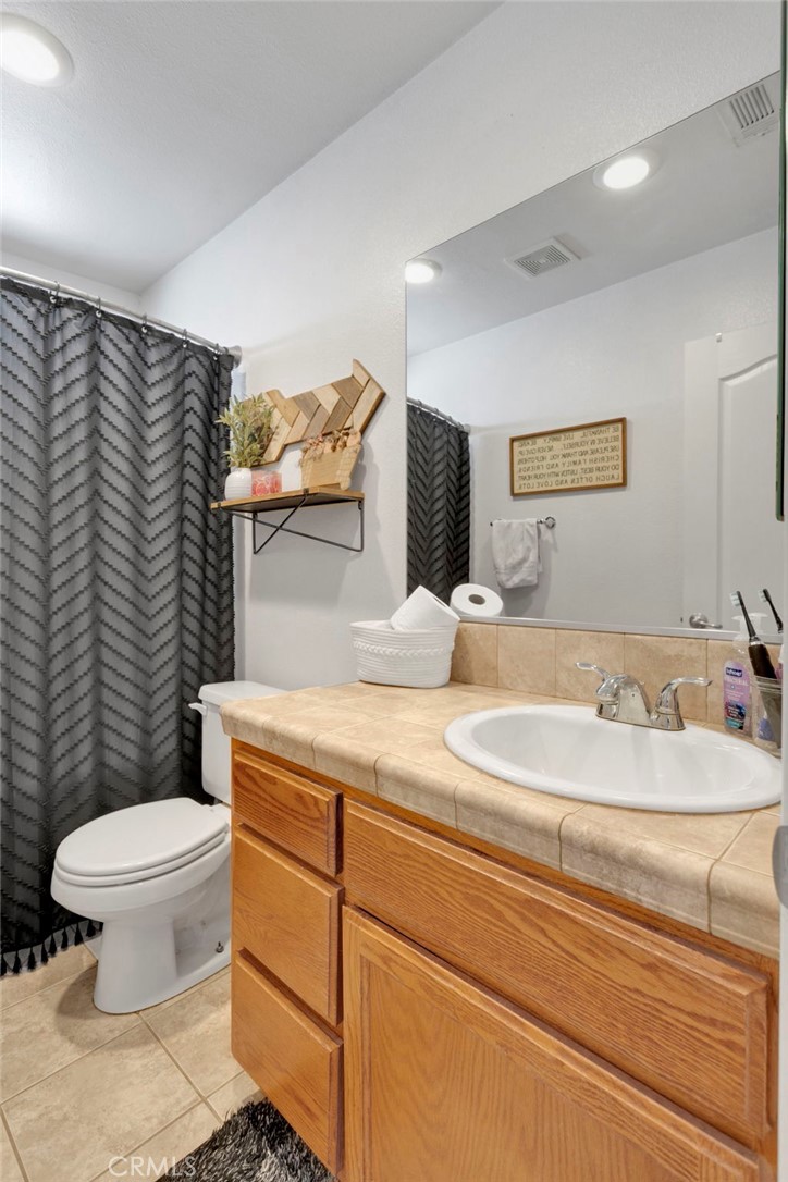 12871 Alta Vista Road Pinon Hills, CA 92372 - Photo 16 of 40 a bathroom with a granite countertop toilet sink and mirror