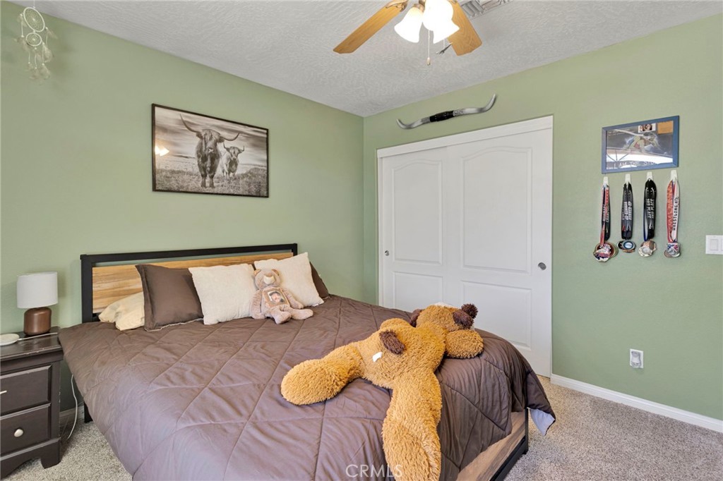 12871 Alta Vista Road Pinon Hills, CA 92372 - Photo 19 of 40 a bedroom with a bed and a chandelier