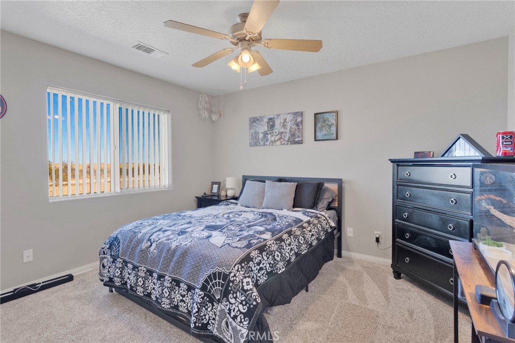 12871 Alta Vista Road Pinon Hills, CA 92372 - Photo 25 of 40 a bedroom with a bed and a chandelier