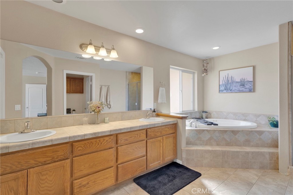 12871 Alta Vista Road Pinon Hills, CA 92372 - Photo 29 of 40 a spacious bathroom with a granite countertop sink a mirror and a