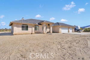 12871 Alta Vista Road Pinon Hills, CA 92372 - Photo 40 of 40 a front view of a house with a yard and garage