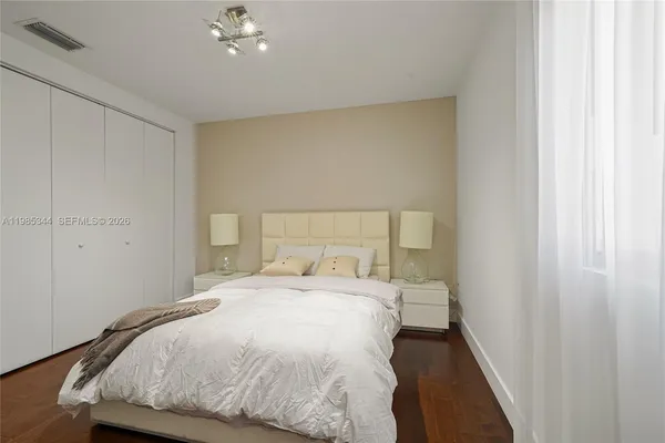 a bedroom with a bed and a painting on the wall