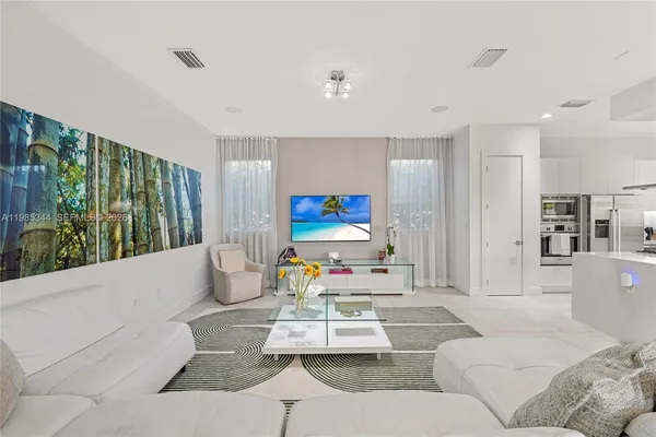 a living room with furniture and kitchen view