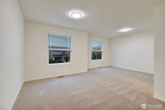 an empty room with fireplace and windows