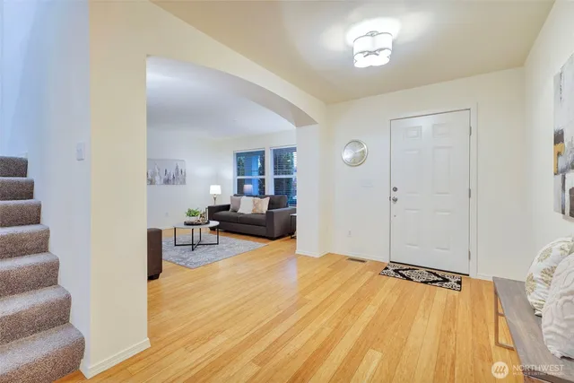 a living room with furniture and a wooden floor