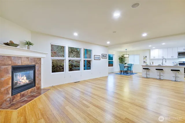 a view of a living room a kitchen with a fireplace and wooden floor