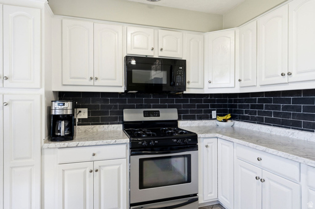 935 900 North Bountiful, UT 84010 - Photo 12 of 46 Kitchen with stainless steel gas range, white cabinetry, black microwave, and tasteful backsplash