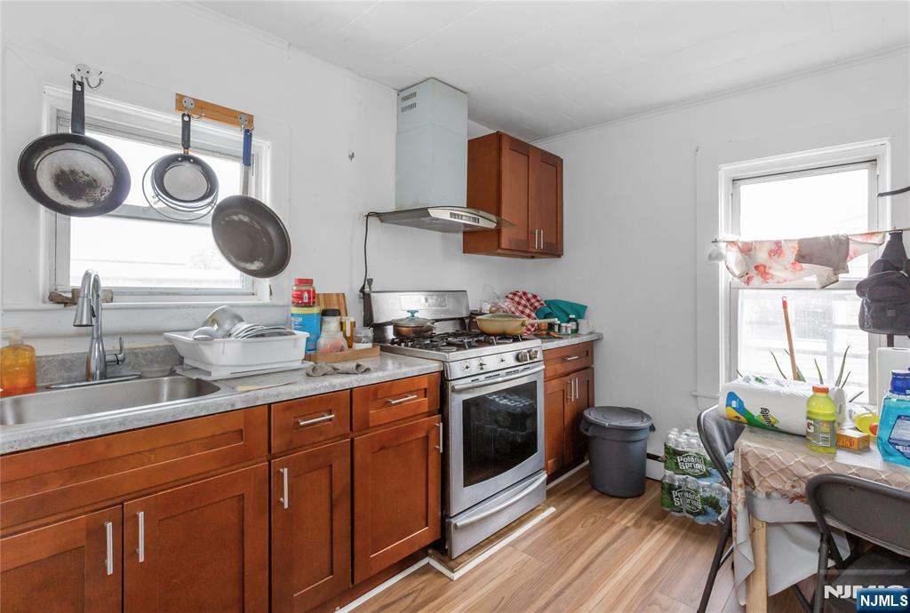 120-122 Lodi Street Hackensack, NJ 07601 - Photo 14 of 50 a kitchen with wooden cabinets a stove a sink and a window