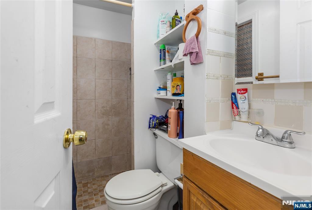 120-122 Lodi Street Hackensack, NJ 07601 - Photo 19 of 50 a bathroom with a sink vanity mirror and toilet