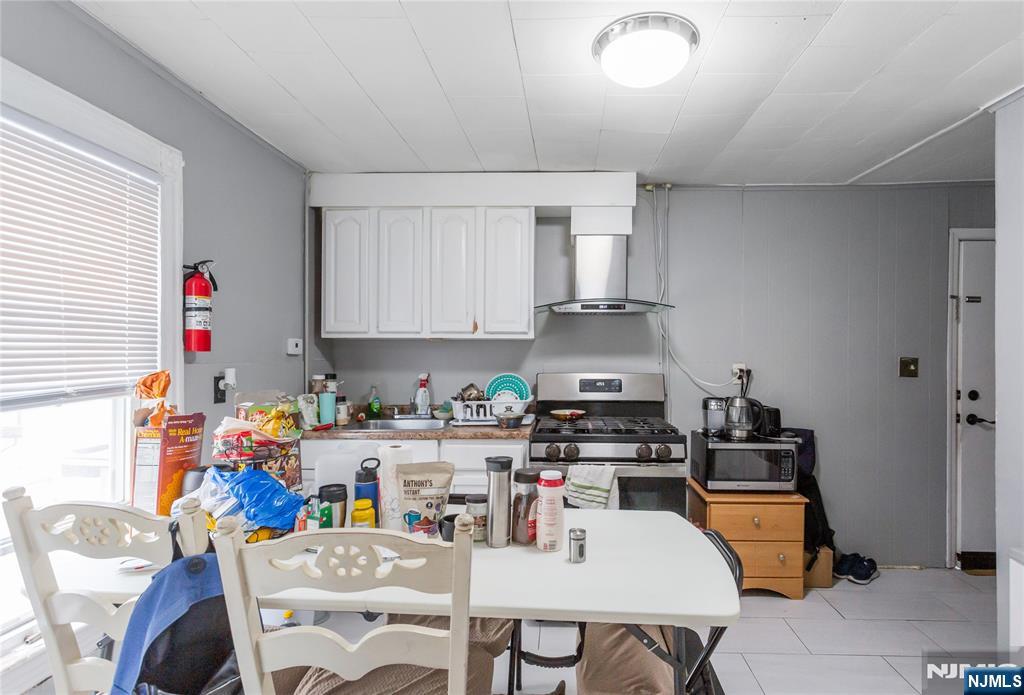 120-122 Lodi Street Hackensack, NJ 07601 - Photo 21 of 50 a kitchen with stainless steel appliances kitchen island granite countertop a sink a stove a dining table and chairs