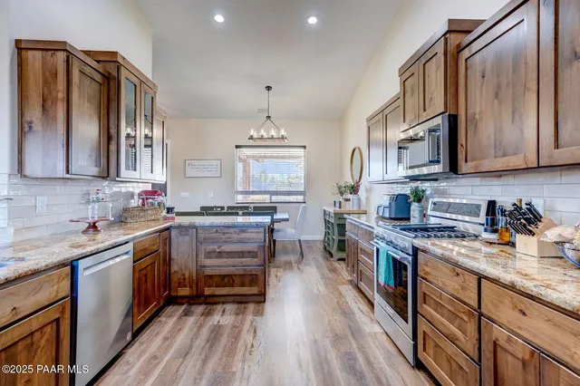 a kitchen with stainless steel appliances granite countertop a stove and cabinets