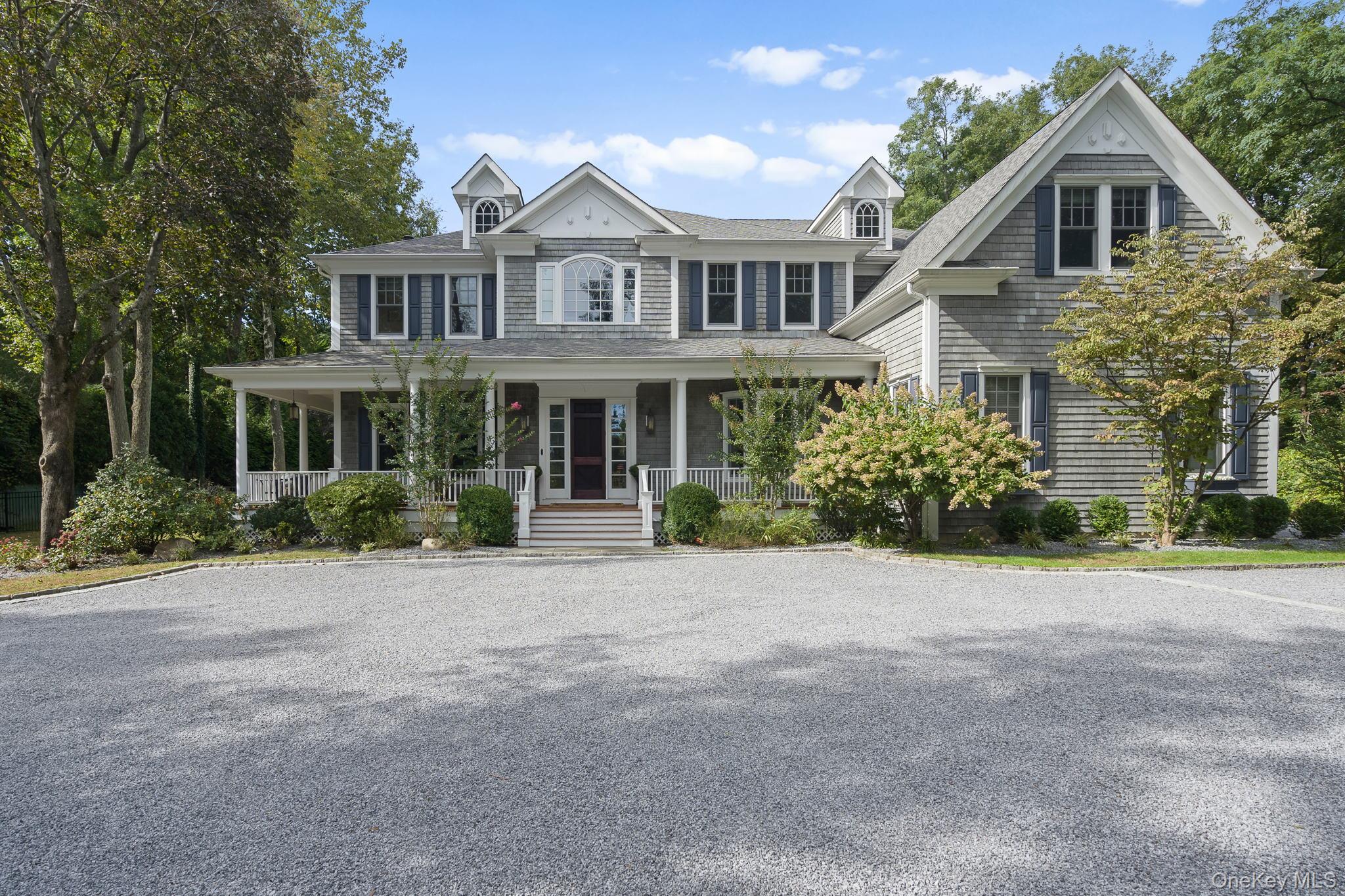 a front view of a house with a yard and potted plants