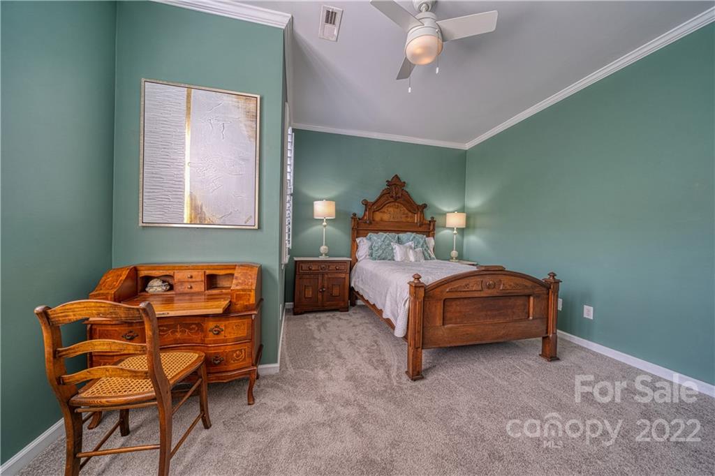 2086 Calloway Pines Drive Tega Cay, SC 29708 - Photo 33 of 47 a bedroom with a bed and a chandelier