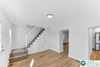 a view of entryway and hall with wooden floor